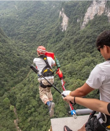 Brave tourists are experiencing bungee jumping at Zhangjiajie Grand Canyon, taking a leap into the air.