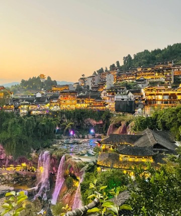 At night, the grand waterfall is surrounded by glowing lights.