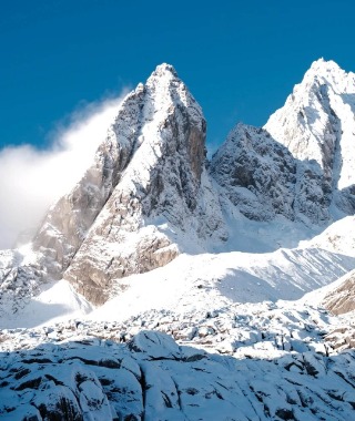 The peak of Jade Yulong Snow Mountain is covered in a thick layer of white snow.