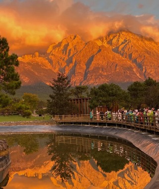 Sunlight hits the peak of Jade Dragon Snow Mountain, turning it instantly into a golden mountain.