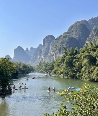 The bamboo raft floats on the Li River in Guilin, with the beautiful Guilin mountains nearby.