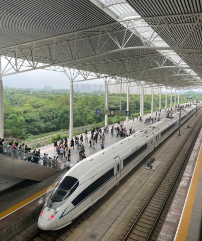 Many people are waiting for the high-speed train to arrive at the station.