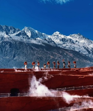 Performers are dancing at the highest point of the red stage.