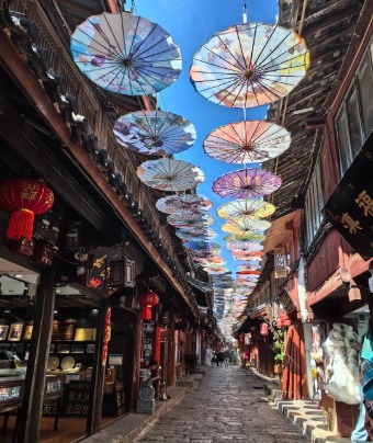 Traditional Chinese oil paper umbrellas are hanging above the streets in Lijiang Old Town.