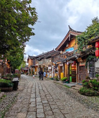 The cobblestone streets of Lijiang Old Town are lined with traditional wooden Chinese buildings.