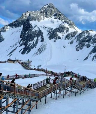 Tourists are walking down the mountain on a wooden walkway.