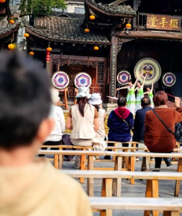 Tourists are watching a performance in Furong Ancient Town.