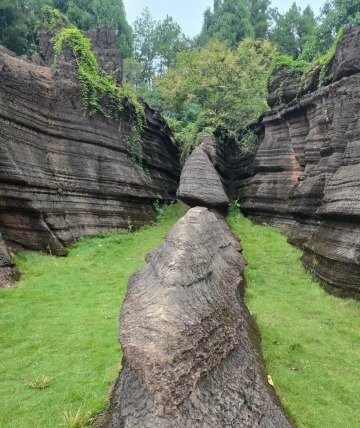 Grass fields stretch on both sides of the rocks.