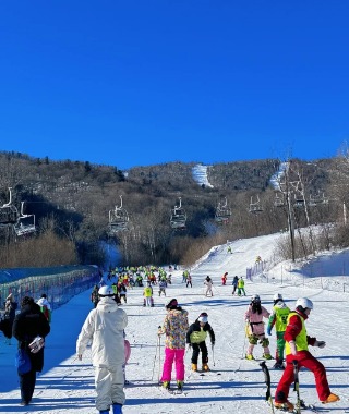 People are skiing at a ski resort in Harbin, dressed in colorful ski outfits.