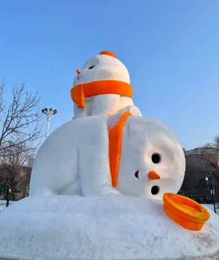 A round, cartoonish snowman wrapped in an orange scarf, looking very lively.