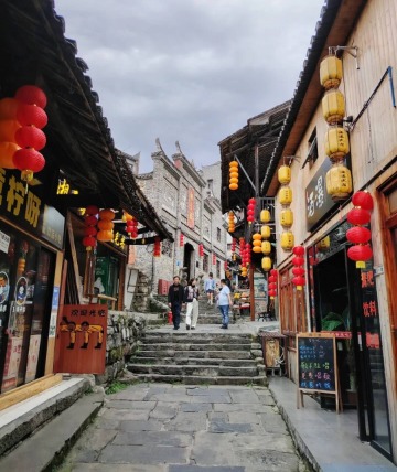 Tourists are exploring the stone-paved street.