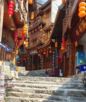 The stone-paved streets of Furong Ancient Town are lined with traditional Chinese wooden buildings.