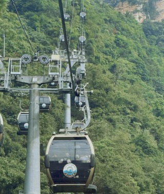 Tourists are sitting in the cable car at Zhangjiajie National Forest Park, taking in the scenery.