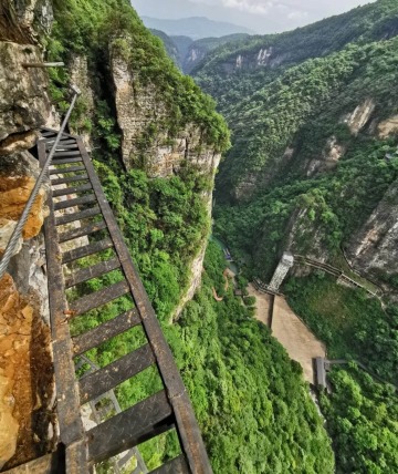 During the Via Ferrata experience, looking down reveals a sheer cliff.