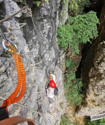 Tourists are climbing the cliff walls of Zhangjiajie Grand Canyon.