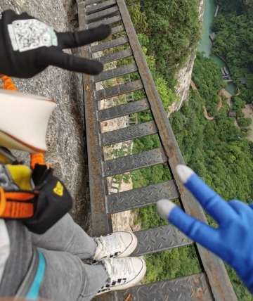 Tourists are taking photos to capture the moment during the Via Ferrata experience.