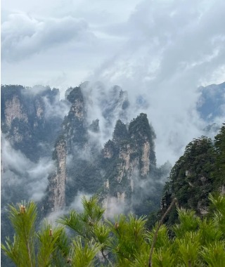 A large mist cloud rises into the sky from the peaks of Yangjiajie.