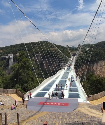 Many tourists take photos on the Zhangjiajie Glass Bridge.